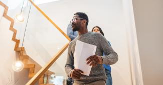 Man walking down stairs holding paper