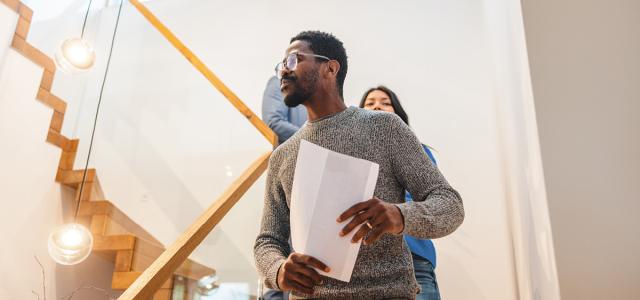 Man walking down stairs holding paper